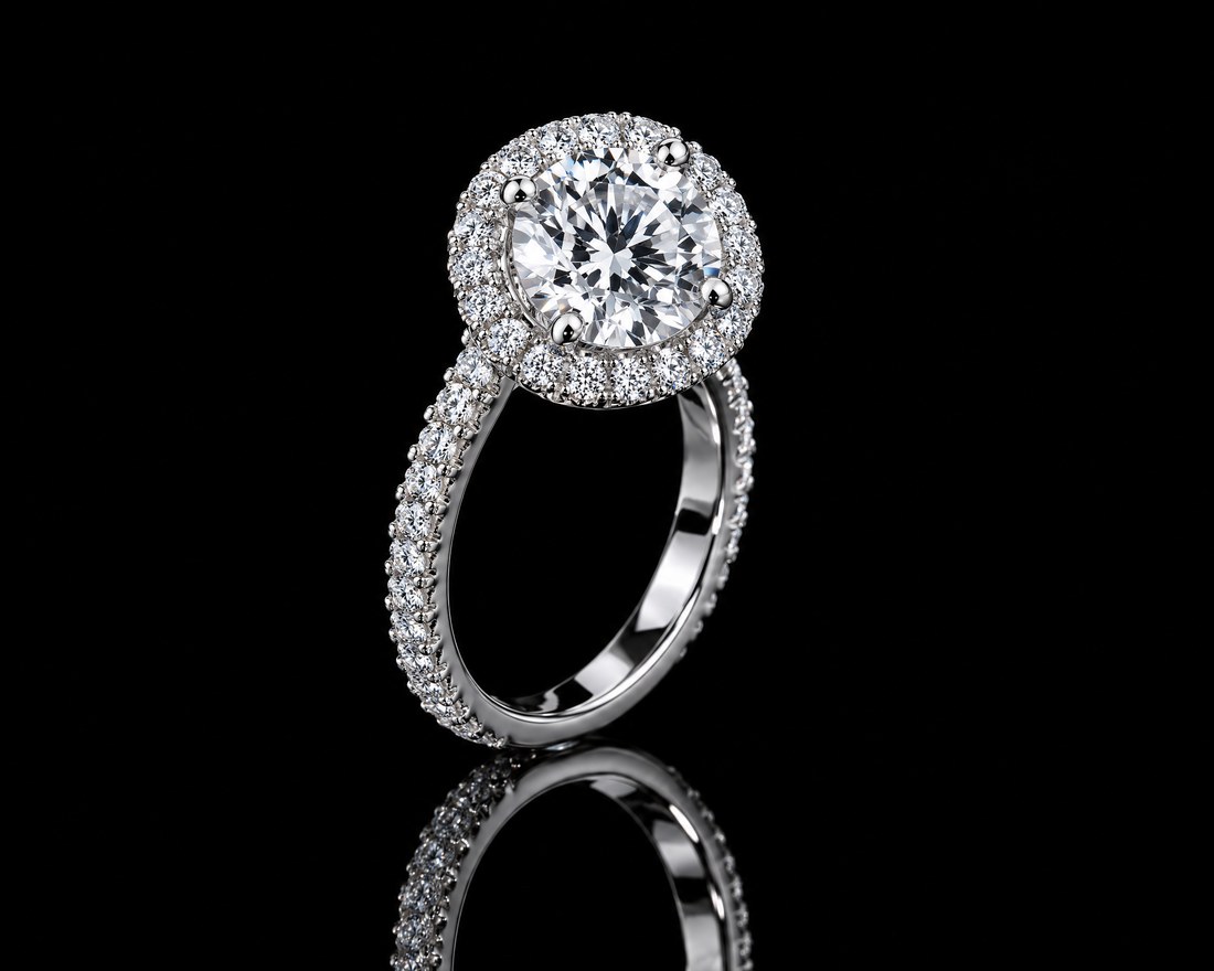 Round brilliant diamond halo ring with a pav&eacute; band in white gold