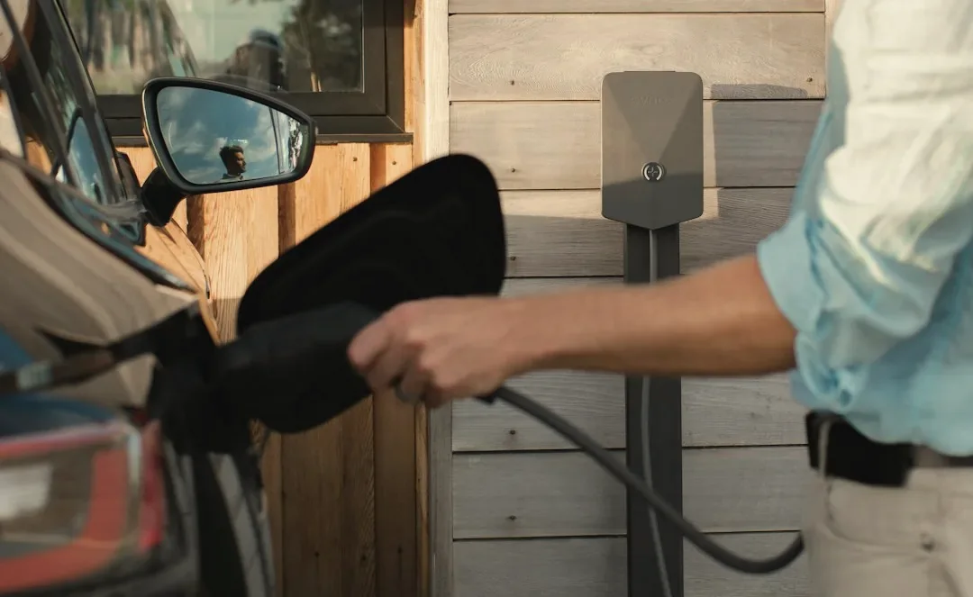 Level 2 EV charger being plugged into a car at home